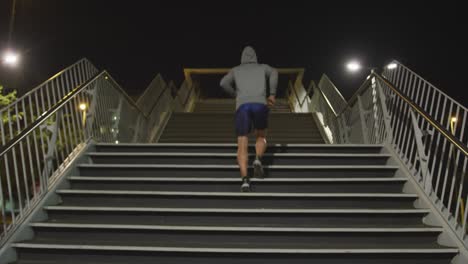 caucasian hooded male doing sport in a street in the evening