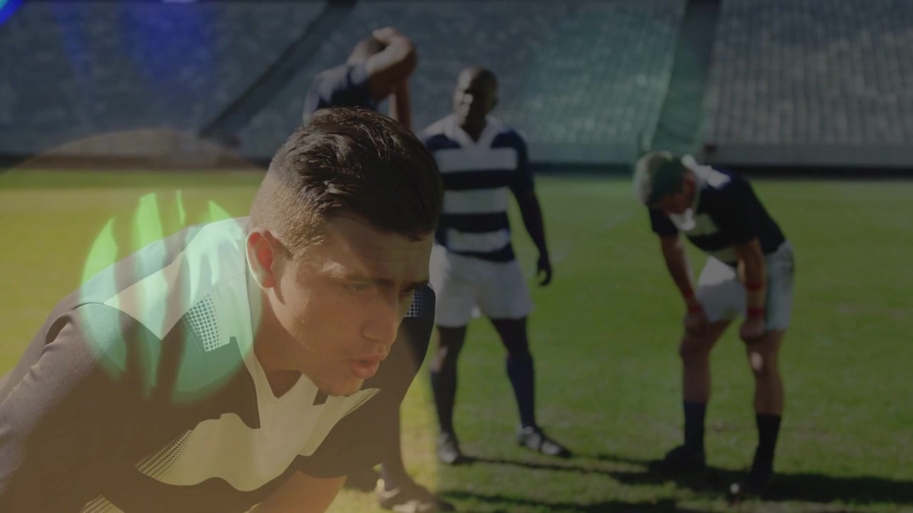 Giocatore sportivo in primo piano su un campo in erba che si alza dopo essersi riposato, la telecamera si avvicina, un bagliore dell'obiettivo si diffonde.