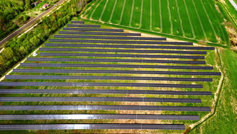aerial top shot of solar farm on green field during daytime.