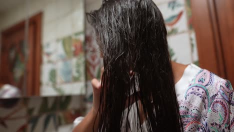 mujer aplicando acondicionador a su cabello en el baño