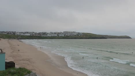 tourists enjoying themselves whilst surfing and walking along Fistral Beach