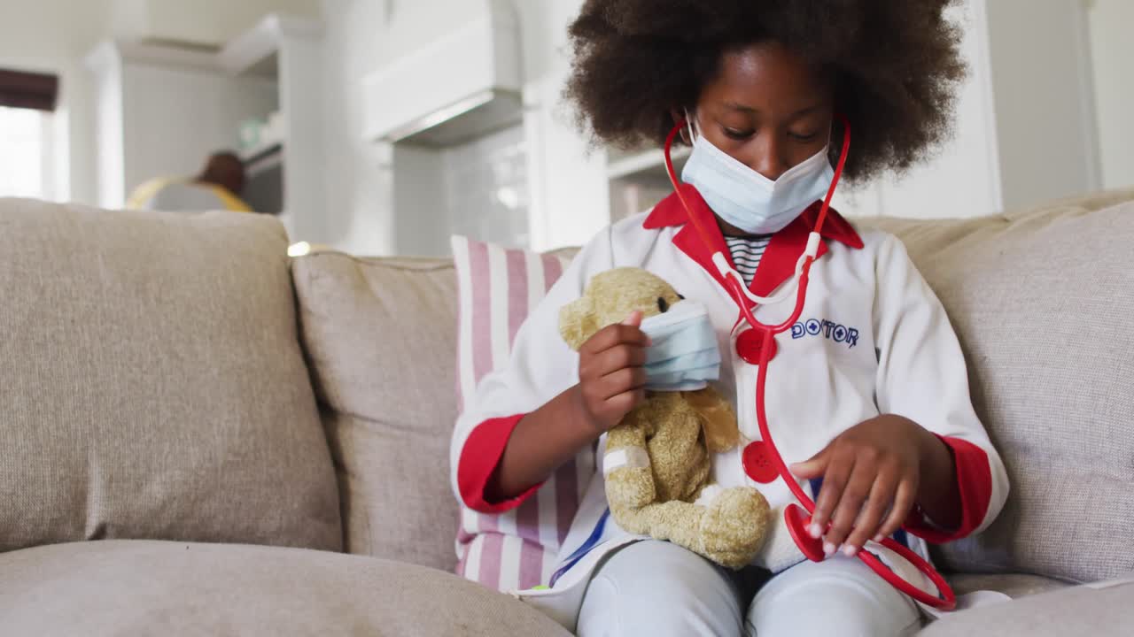 African american girl playing doctor and patient with her teddy bear