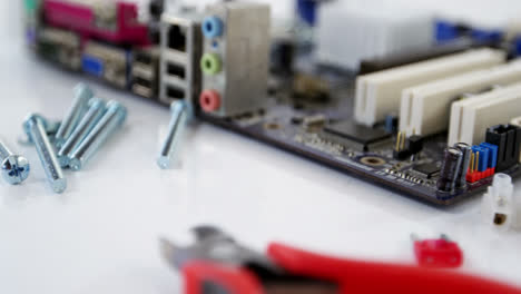 varias herramientas de trabajo y placa base en la mesa