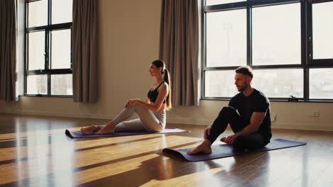 couple practicing yoga in a studio