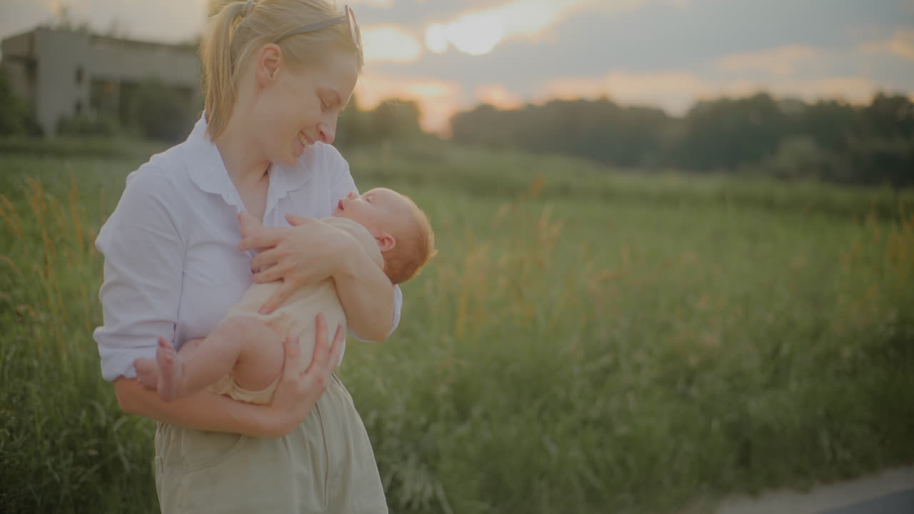 Mother Kissing Newborn Son at Sunset
