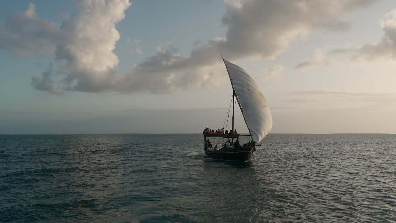 전형적인 아프리카 배가 해가 지면 바다에서 항해합니다.