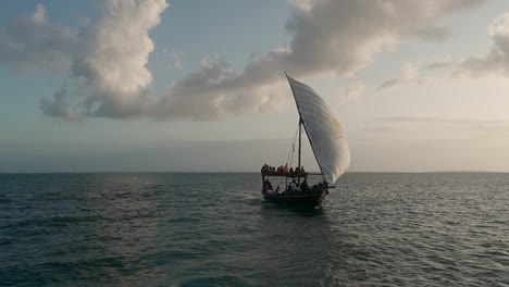 typical african boat sails in the ocean at sunset