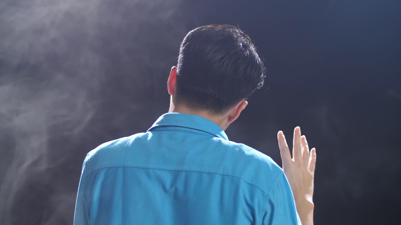 연기 배경으로 파란 셔츠를 입은 남자