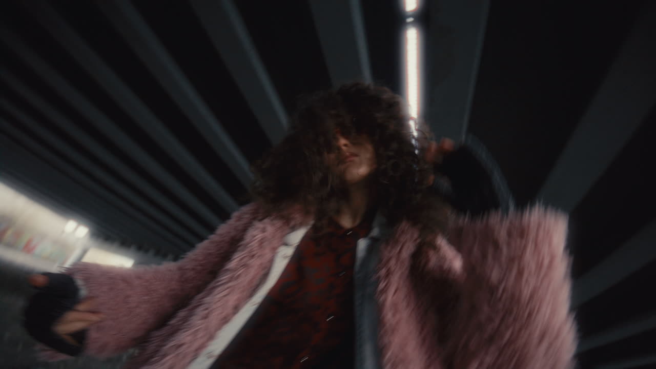 Confident Girl Dancing and Looking at Camera under Highway Overpass