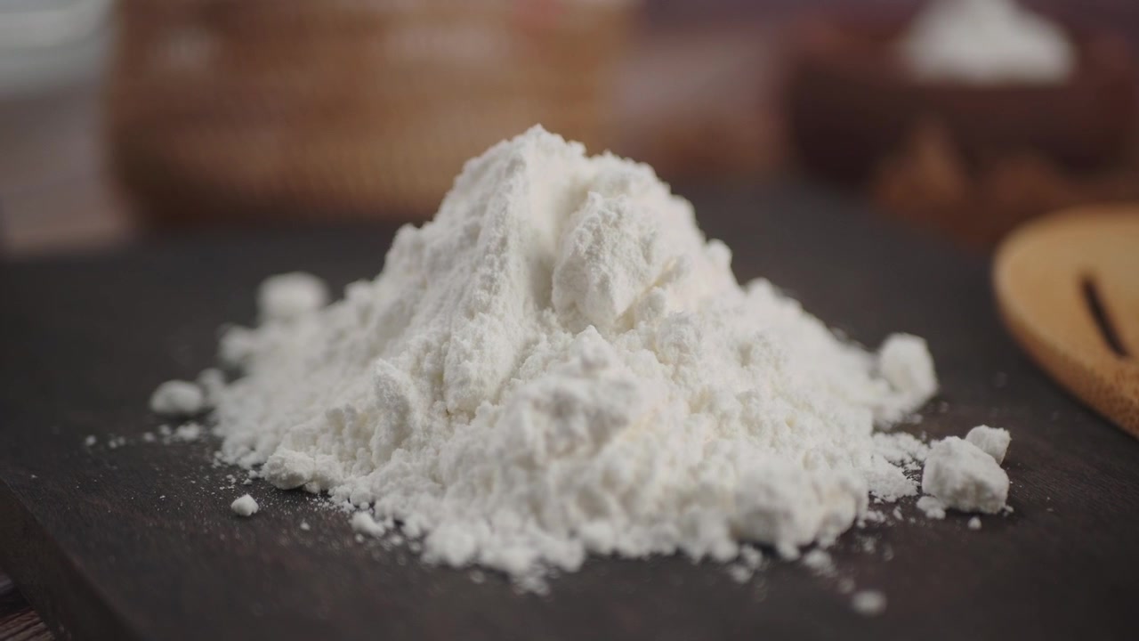 Cumulo di farina bianca su una superficie di legno scuro