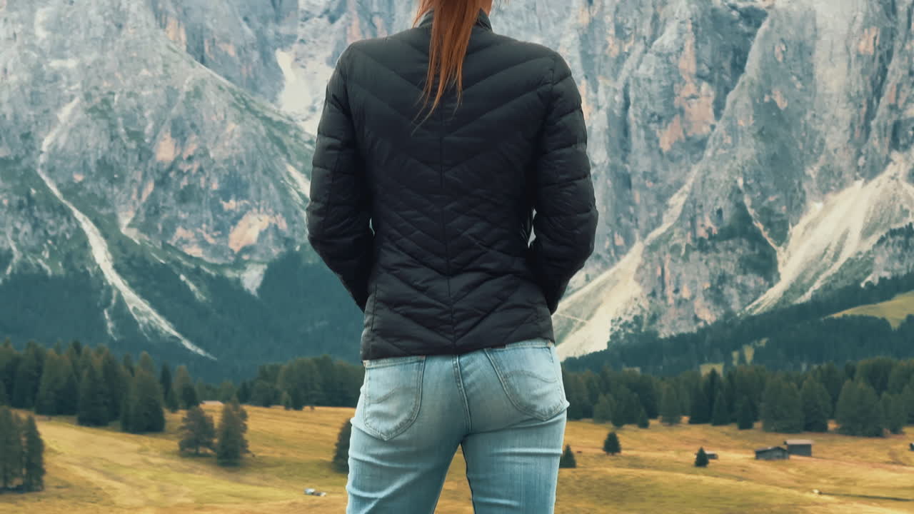 Tourist enjoying breathtaking mountain view in Alpe di Siusi, Dolomites, Italy, in slow motion