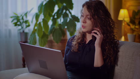 Portrait-Of-Businesswoman-Working-On-Laptop-While-Talking-On-Mobile-Phone-1