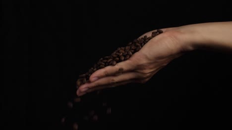 coffee beans in male hand, slow motion