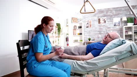 Female-caretaker-talking-with-old-and-sick-man