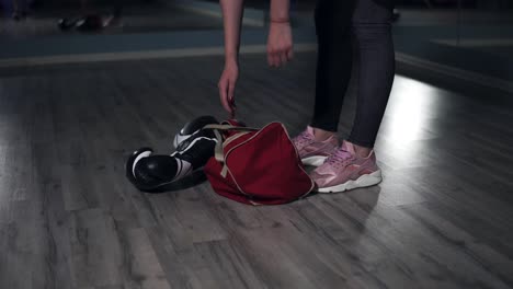 Closeup-view-of-woman's-legs-walking-in-a-boxing-club.-Young-female-boxer-putting-down-her-bag-and-taking-out-a-bottle-with-water-preparing-for-training.-Shot-in-4k