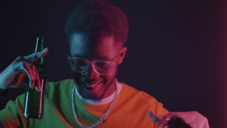 happy man holding beer bottle in neon light