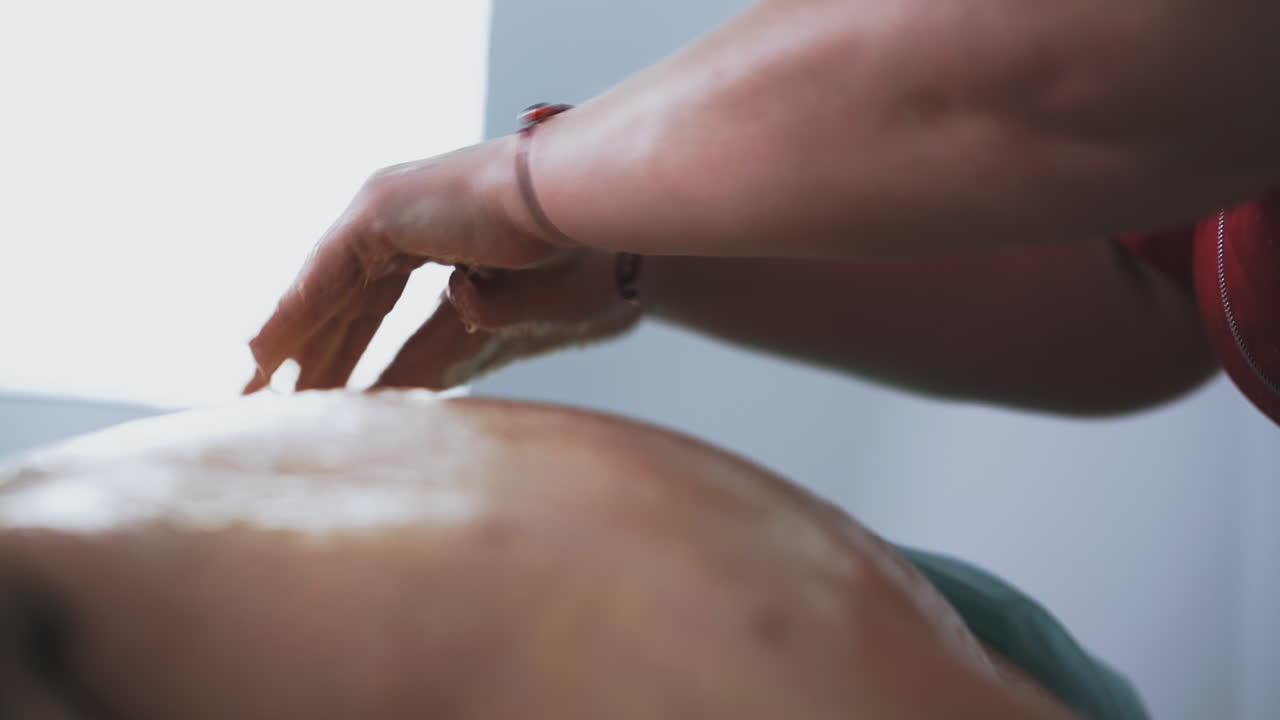 uno specialista fa massaggi di miele a un paziente maturo in clinica