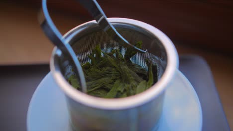 soak green taiping houkui tea leaves on a metal filter