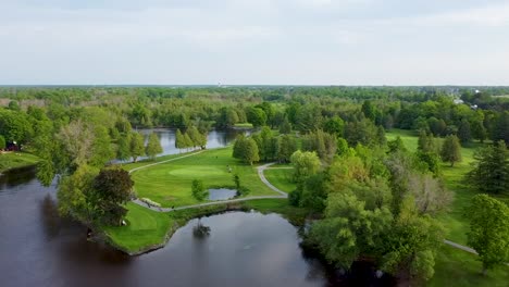 Drone-circling-over-a-golf-course-surrounded-by-a-lake