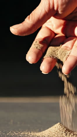 hand pouring sand