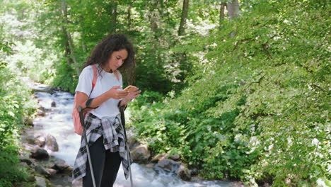 injured woman using phone by a stream in a forest