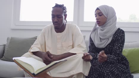 african muslim couple at home in ramadan reading quran holly islam book