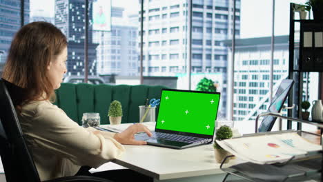 Business-director-working-in-her-own-office-with-green-screen