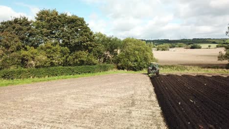 aerial footage over tractor ploughing field