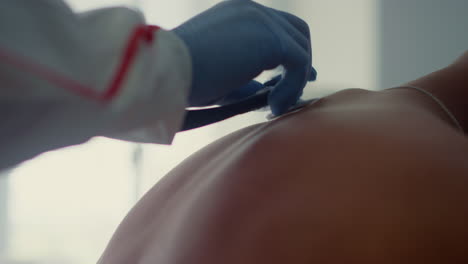 Doctor-hands-listening-lungs-with-stethoscope-in-infectious-department-closeup.