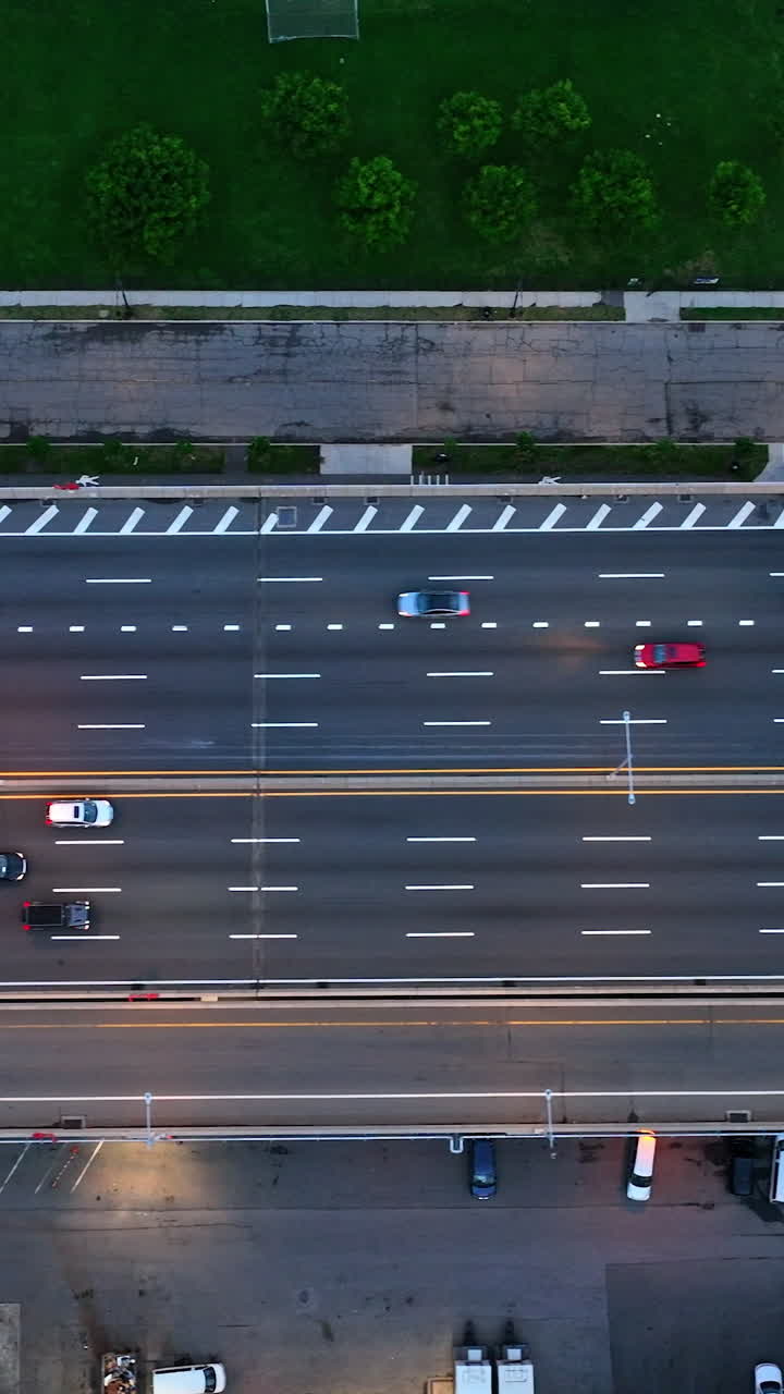 Two directions multi-lane highway in New York. Road leading to the bridge with parking lot under. Birds' eye perspective. Vertical video