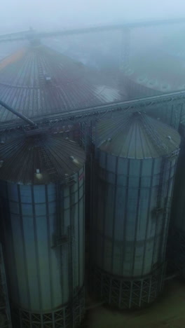 gloomy sight of an agricultural granary plant. view from above on the modern elevator for grain storage. foggy winter weather background. vertical video