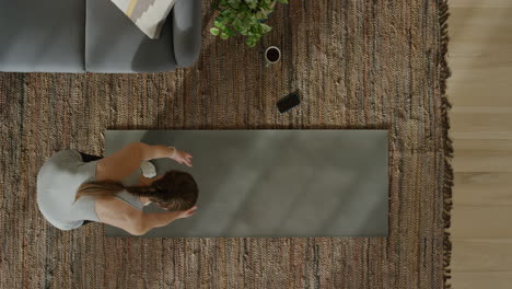 vista superior de una mujer de yoga practicando pose de guerrero ejercitando un estilo de vida saludable entrenando en casa en una colchoneta de ejercicios disfrutando de la meditación de atención plena