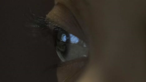 macro of right eye blinking watching television at night, eye reflected screen