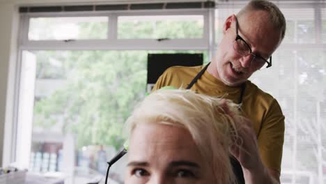 Front-view-woman-having-her-hair-dry-by-a-hairdresser