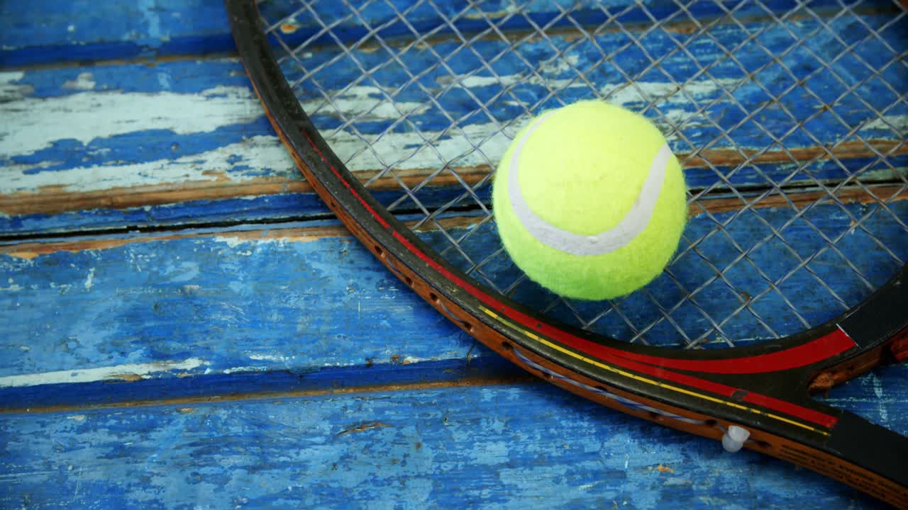 Tennis ball and racket on wooden plank 4k