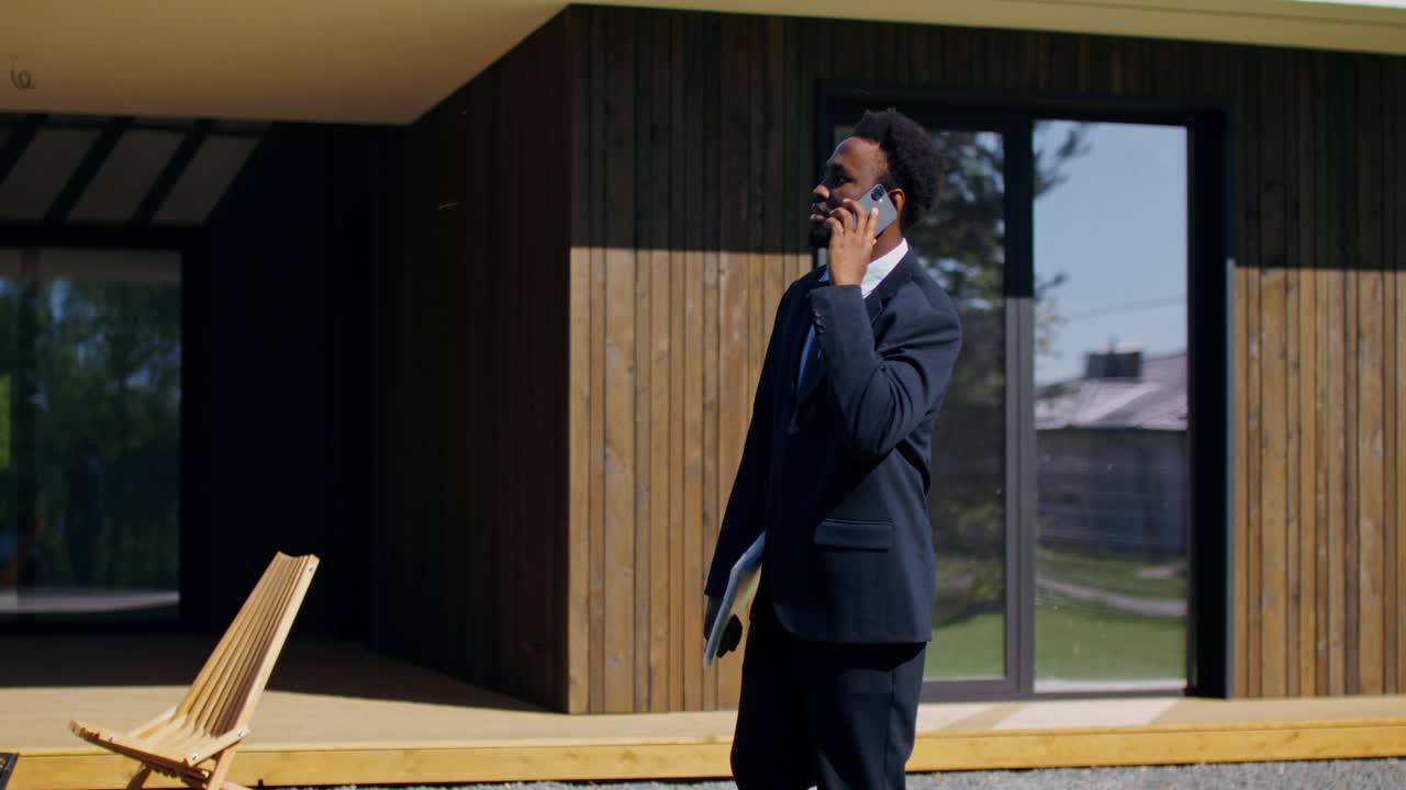Real Estate Agent Talking on Phone Outside Modern House