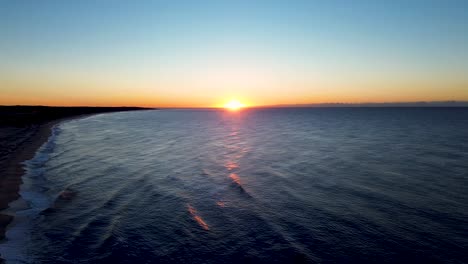 drone aerial landscape of golden orange sunrise on horizon coastline with waves breaking on coastal town sandy beach headland the entrance central coast australia travel holidays nature tourism