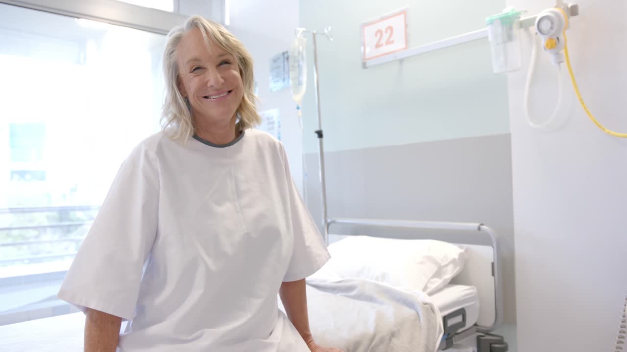 retrato de una paciente mayor caucásica feliz con una pierna protésica sentada en la cama del hospital