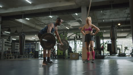 side view of caucasian female monitor and an athletic african american man in the gym.