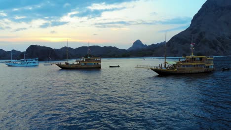 a cruise ship anchored off the coast of padar island, near komodo in indonesia, captured from a drone during the evening