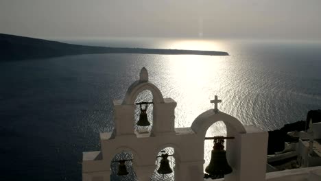 tilt down shot of four church bells in oia, santorini