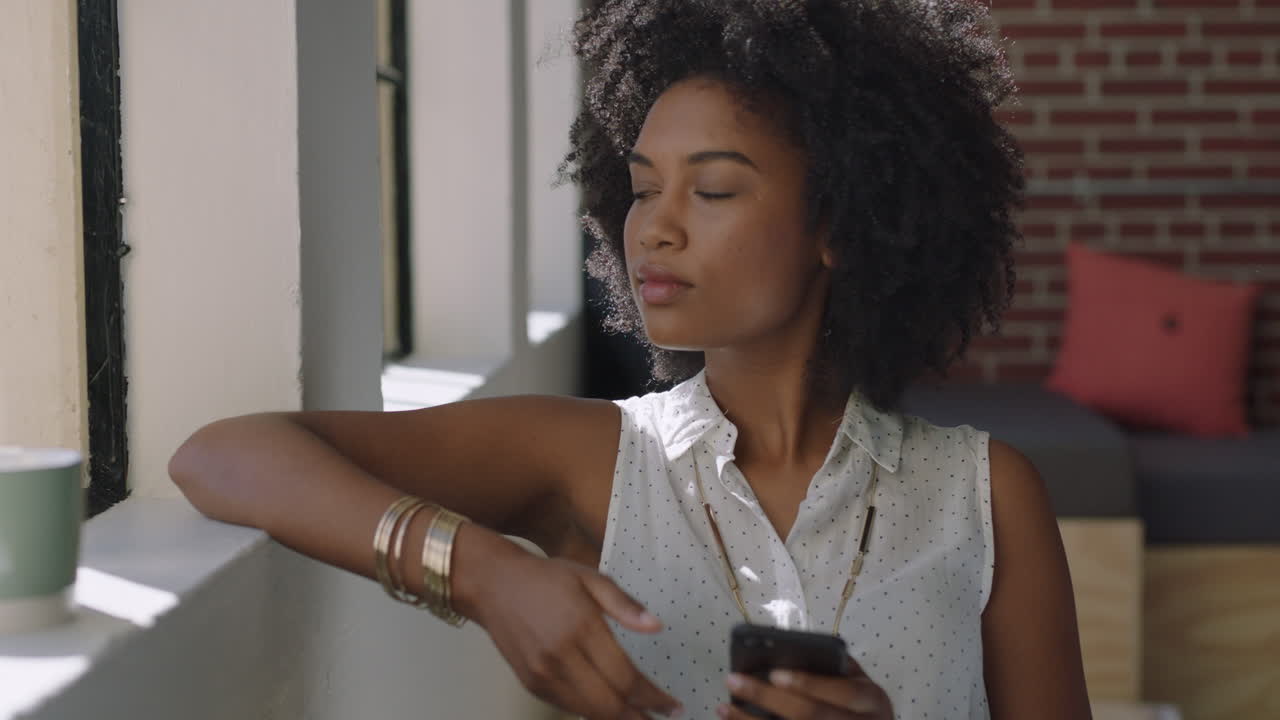 beautiful woman using smartphone at home browsing messages enjoying relaxed lifestyle looking out window planning ahead african american female texting on mobile phone