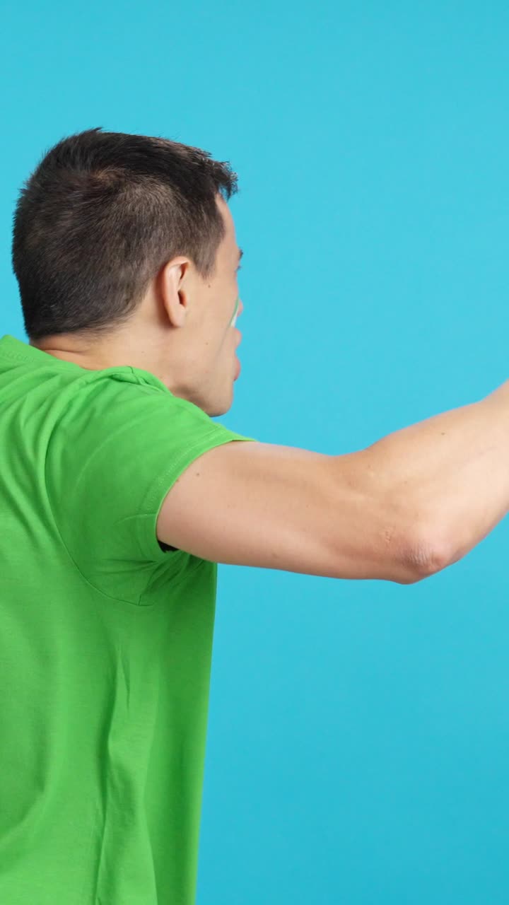 Rear view of a man waving a nigerian pennant
