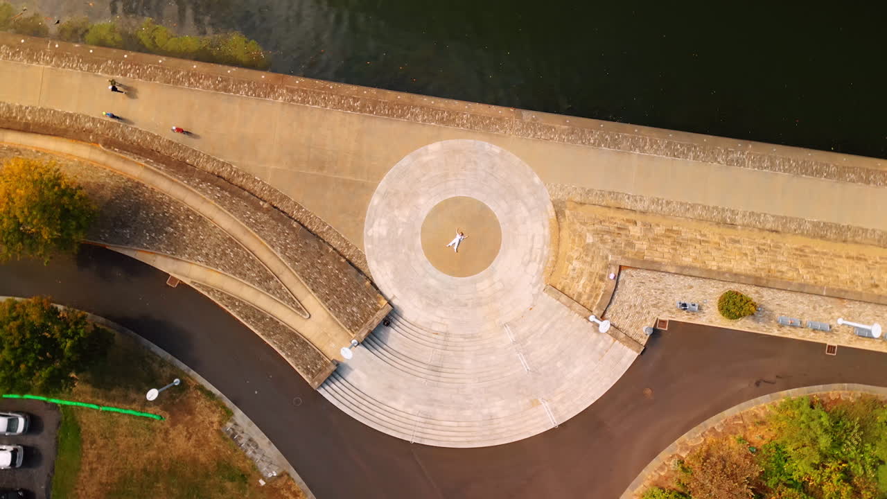 Pittsburgh, USA, 2 August 2025: Circling above the tiled quay of Pittsburg, Pennsylvania, USA. Woman wearing white clothes lies in the center of tiled ornament