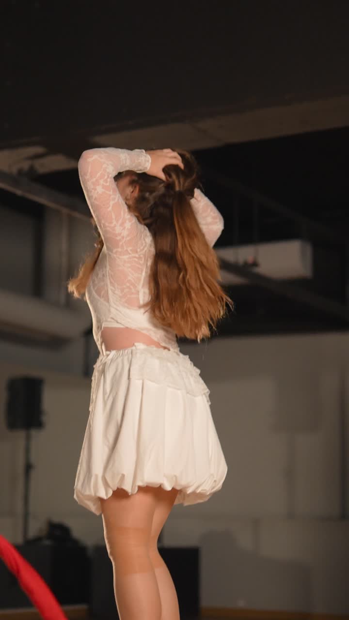 Donne che eseguono danza aerea su tessuti in abiti bianchi
