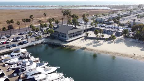 Aerial-View-of-speedboats-in-harbor-close-to-the-beach--Flyover-Dolly-Shot