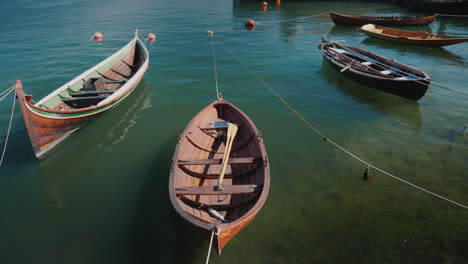 Varios-Barcos-De-Madera-Están-Amarrados-Frente-A-La-Costa,-El-Paisaje-Tranquilo-De-Un-Pueblo-De-Pescadores-4k-Video