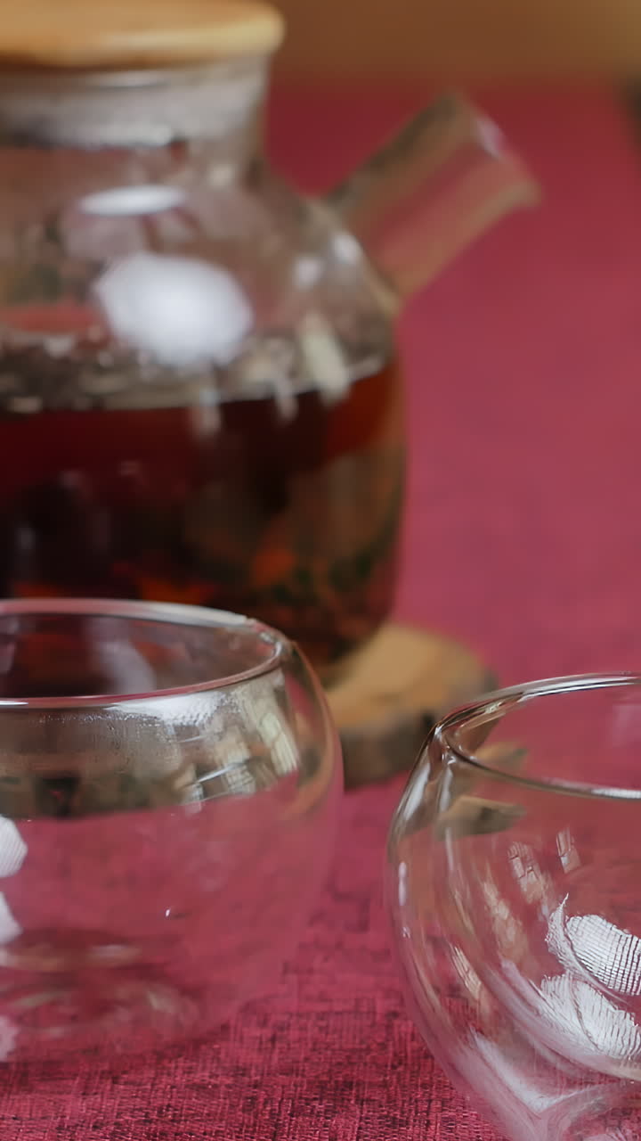 vertiendo té en tazas de vidrio