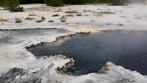 sizzling water of hotspring at grand prismatic spring during daytime in yellowstone national park at wyoming, united states