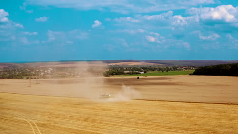 harvesting ripe crop in farmland. large dust from combine harvester on field during agronomy works in rural place. aerial view.